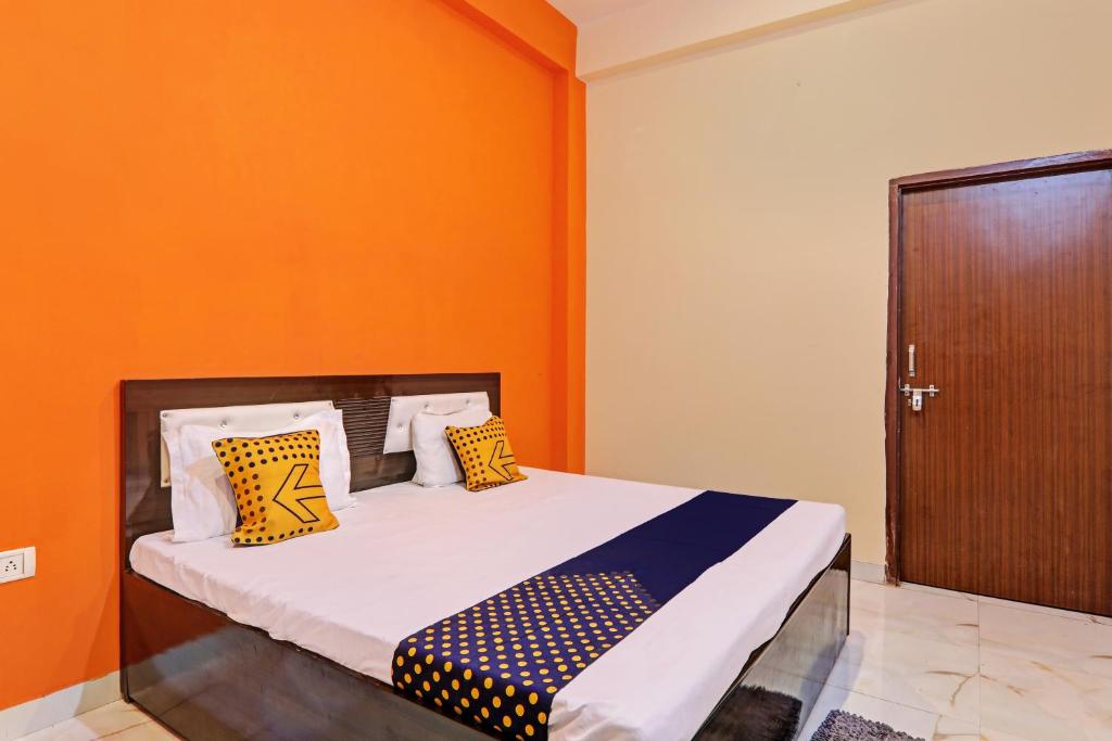 um quarto com uma cama com uma parede laranja em A K Hotel em Rasūlābād