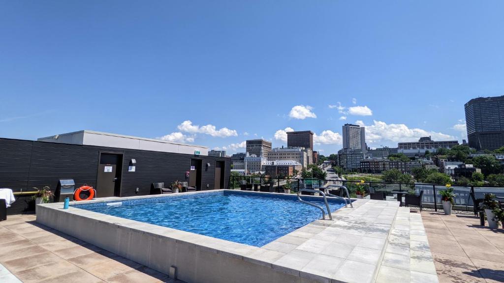 a swimming pool with a city skyline in the background at Suites Caiman in Quebec City