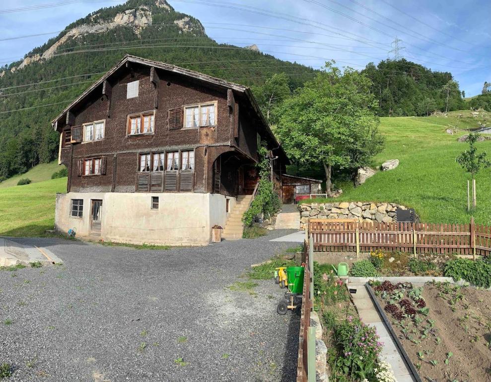 a large wooden house with a mountain in the background at Ferienhaus Unteraxen in Sisikon
