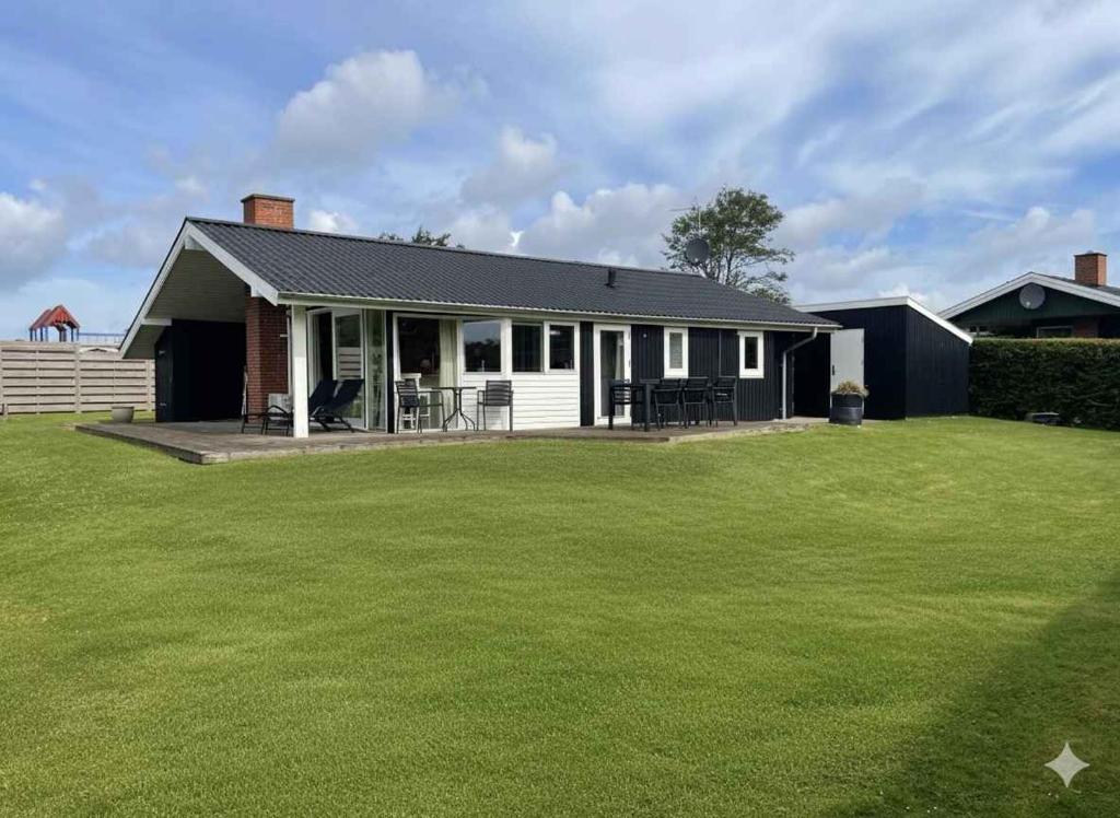 ein Haus mit einem grünen Rasen davor in der Unterkunft Fantastic View And 150 Meters To The Beach in Sønderby