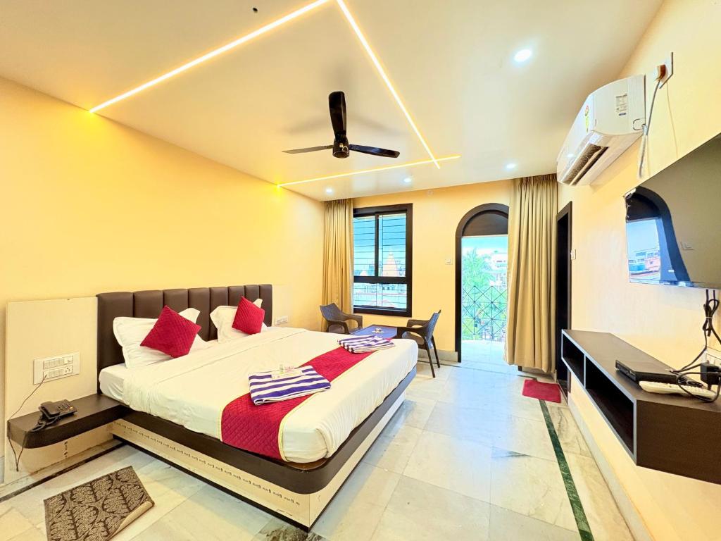 a bedroom with a king sized bed and a desk at বীণাপানি হোটেল & রেস্টুরেন্ট Binapani Tarapith in Tarapith