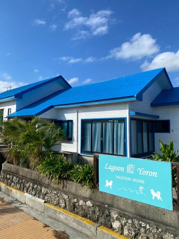 a house with a blue roof and a sign at Lagoon藍yoron 一棟貸し in Yoron