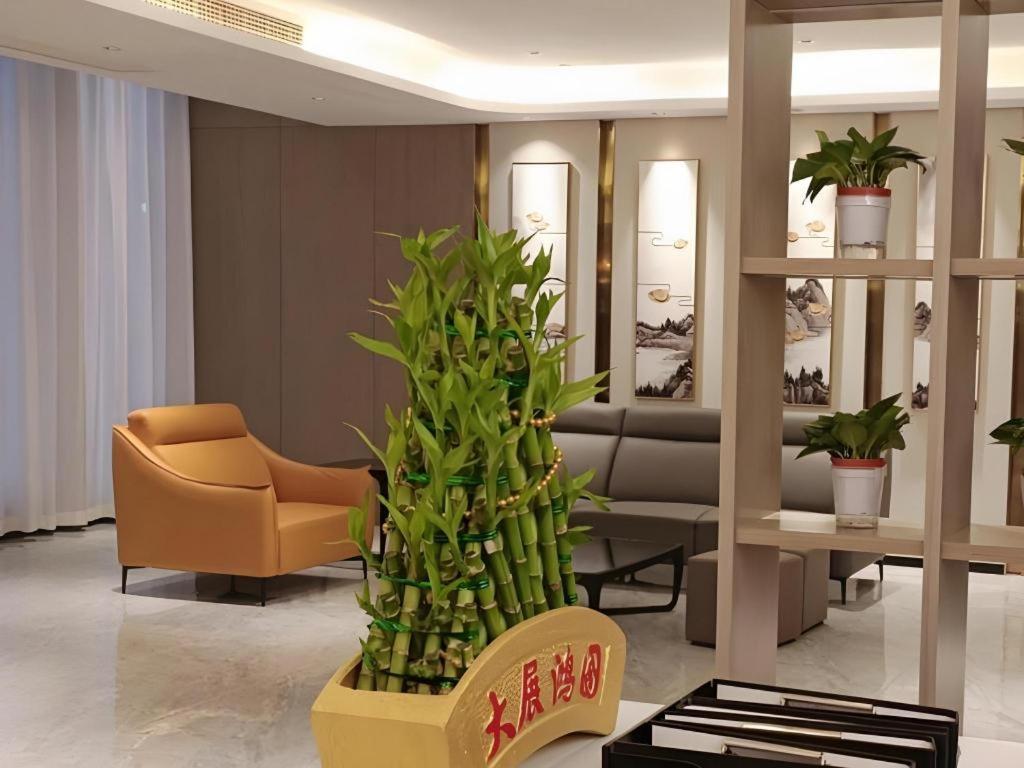 - un hall avec un canapé, une chaise et une plante dans l'établissement VX Hotel Wuhan Optics Valley Yangjia Bay Metro Station, à Wuhan