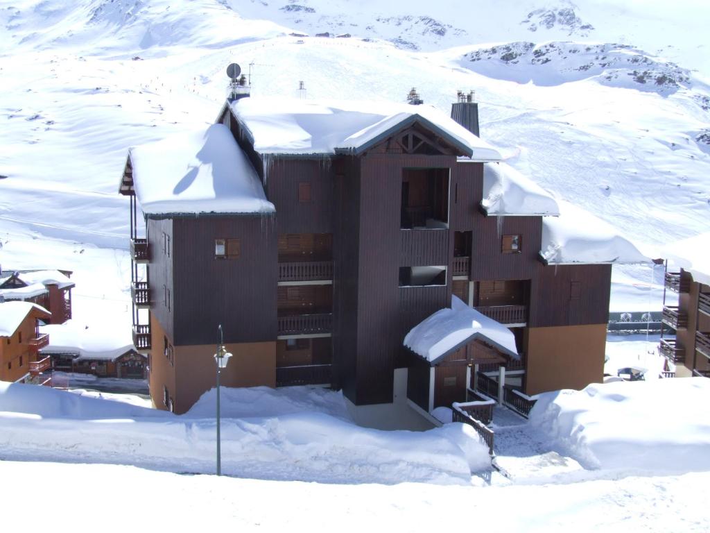 un bâtiment recouvert de neige dans la neige dans l'établissement Beausoleil Appartements VTI, à Val Thorens