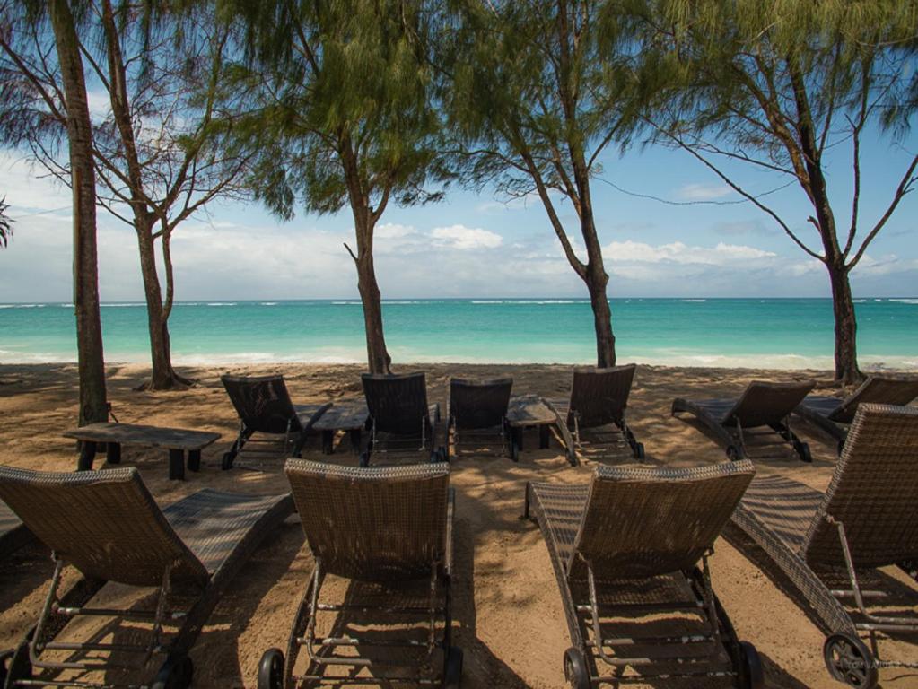 un gruppo di sedie e tavoli sulla spiaggia di Bahari Dhow Beach Villas a Diani Beach