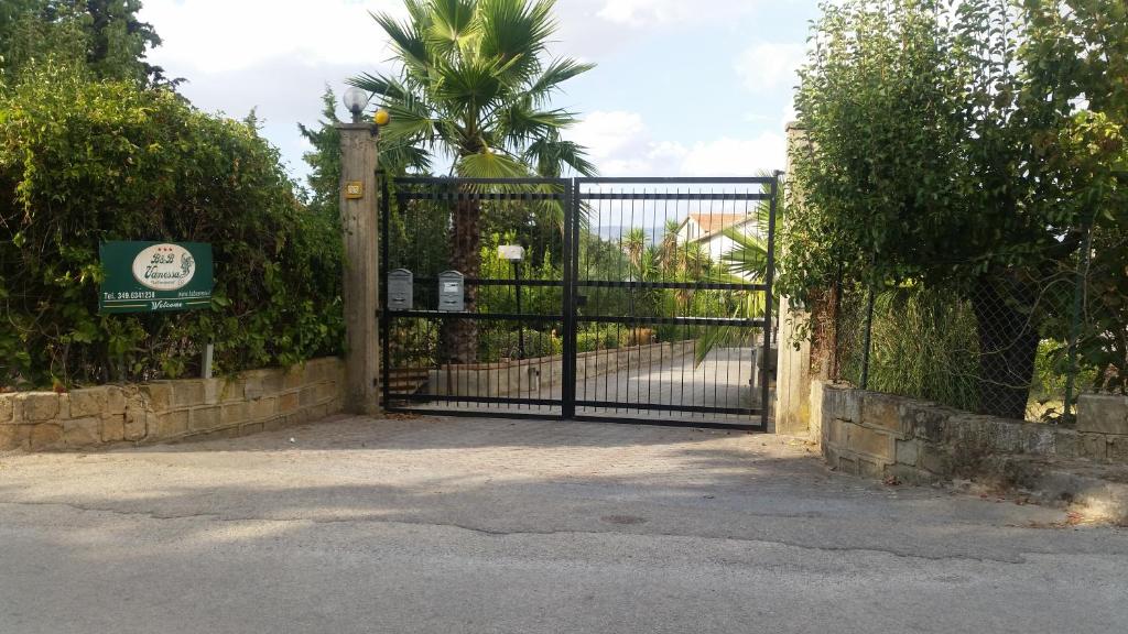 un cancello di ferro con una palma dietro di BeB Vanessa Le Fontanelle a Caltanissetta