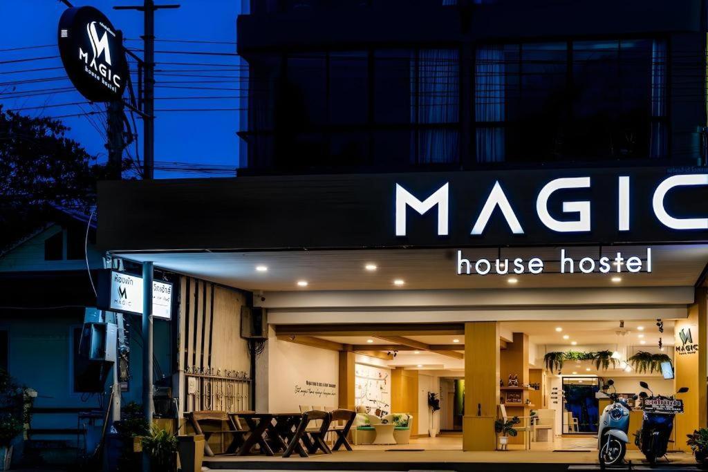 七岩Magic House Hostel的建筑物前立着一块玛吉之家旅舍的标志牌。