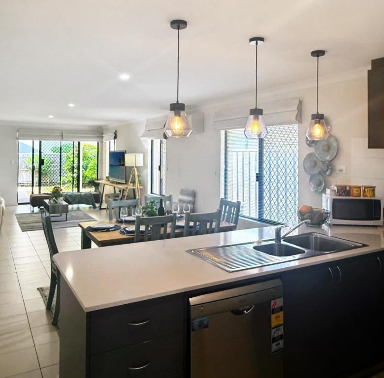 eine Küche mit Spüle und ein Wohnzimmer in der Unterkunft Seascapes And Beaches in Falcon