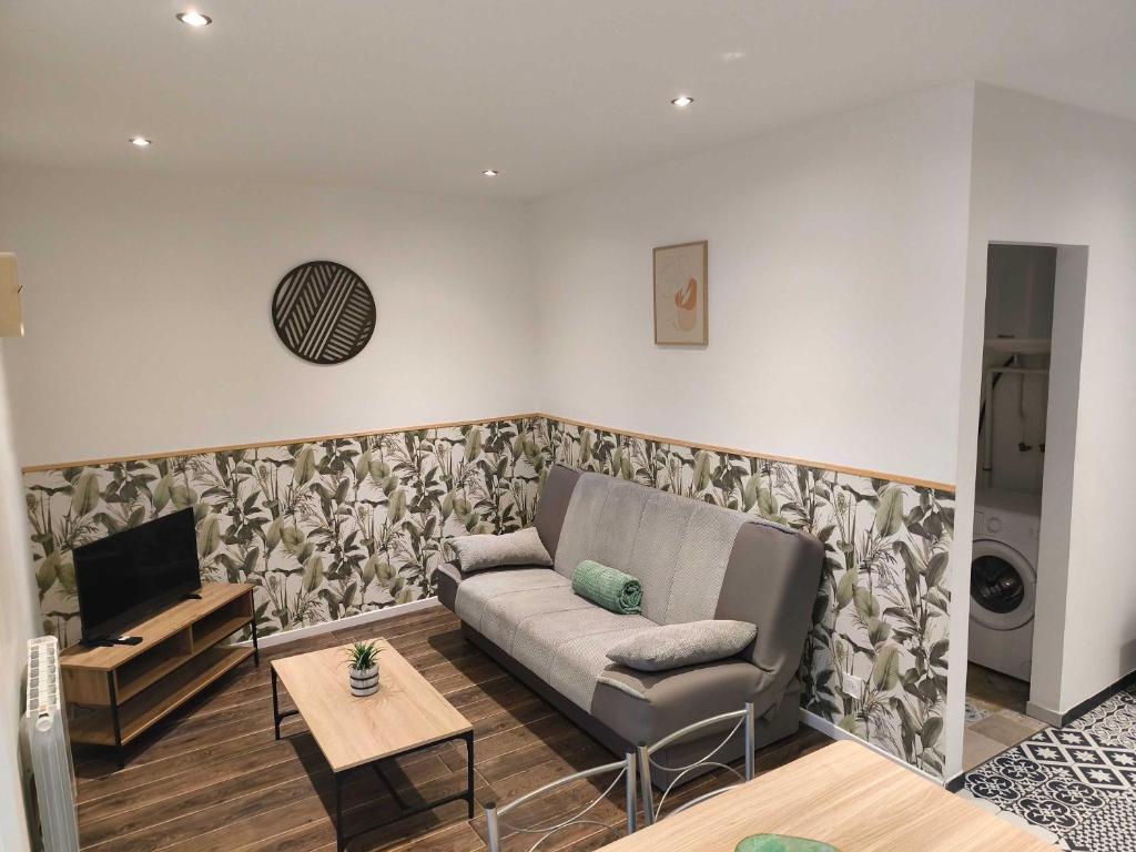 a living room with a couch and a table at Budget Studio avec Parking in Charleville-Mézières