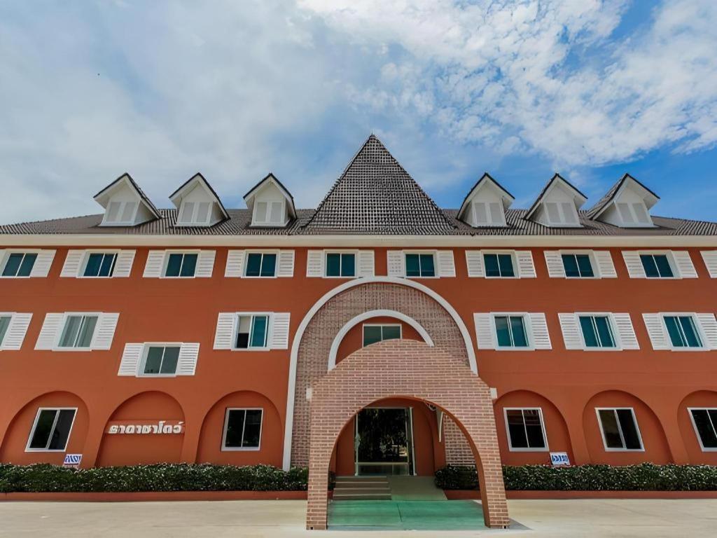 ein großes orangefarbenes Gebäude mit einem dreieckigen Dach in der Unterkunft Thada Chateau Hotel in Ban Bu Lamduan