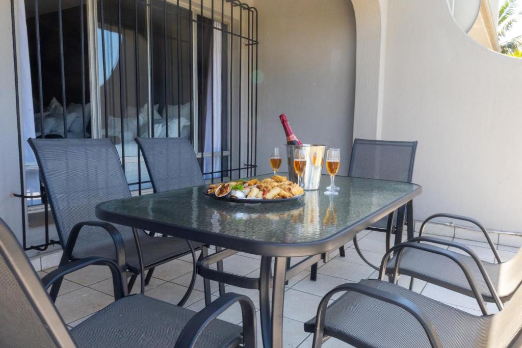 ein Tisch mit einem Teller Essen und Gläsern Wein in der Unterkunft Seagull Apartment -2 Bedroom Apartment 408 by First Private Stays in Margate