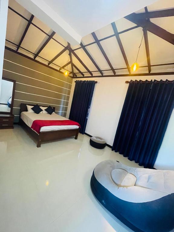 a bedroom with a bed and a couch in it at Woori House in Kamburugamuwa