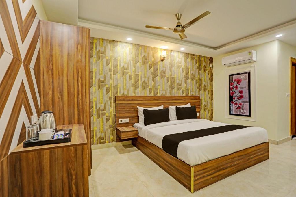 a bedroom with a large bed and a table at Hotel City Lite Near Delhi Airport in New Delhi