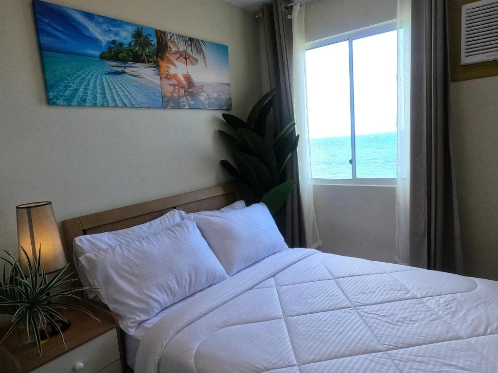a bedroom with a white bed and a window at CONDOTEL MARINA SPATIAL FILINVESt in Piapi