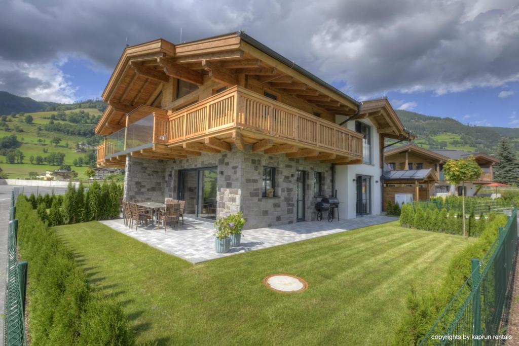 a house with a wooden roof on a lawn at Deer & Dear Luxury Chalet in Piesendorf