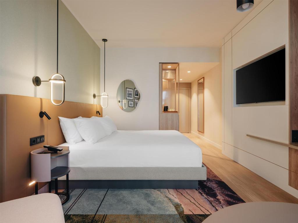 ein Hotelzimmer mit einem Bett und einem Fernseher in der Unterkunft Hyatt Place Tallinn in Tallinn