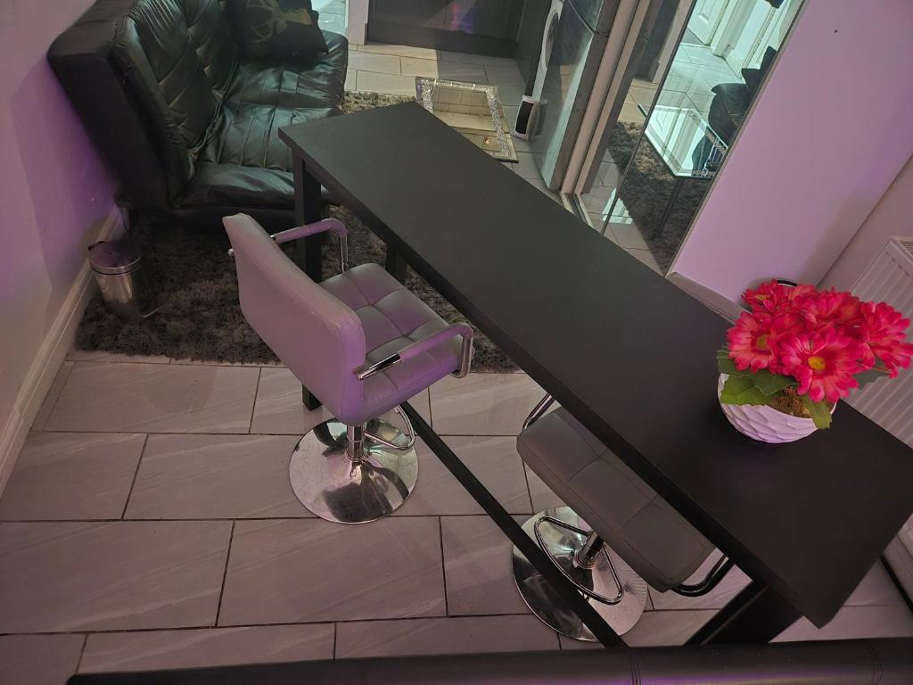 ein lila Stuhl an einem Schreibtisch mit einem Tisch in der Unterkunft Cambridge suites in Cleethorpes