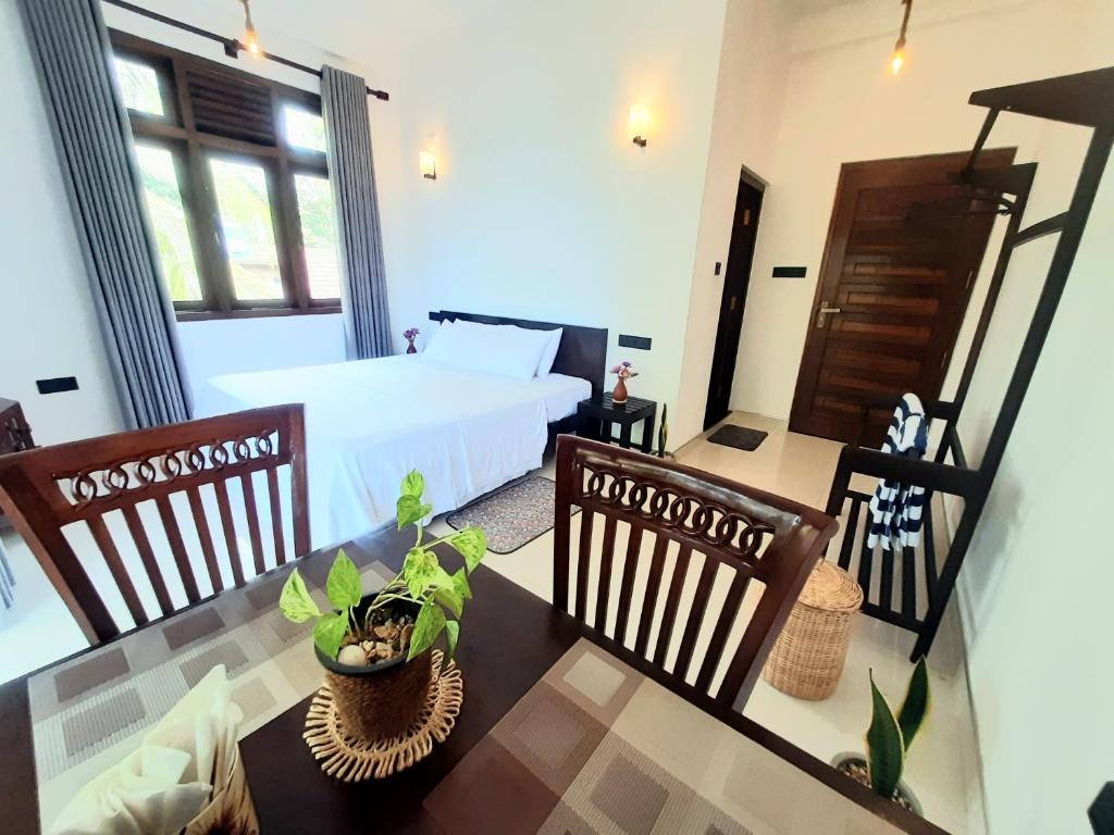 a bedroom with a bed and a table and chairs at Turtle Point Homestay Seaview 2 - BB, Fast Wi-Fi, AC in Dickwella