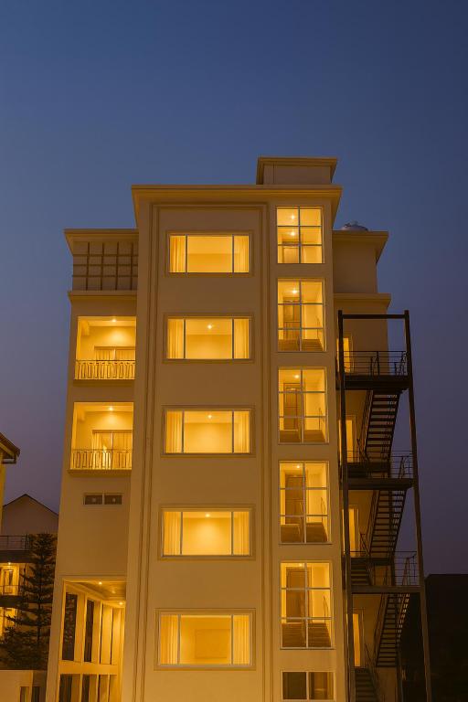 a tall white building with windows and fire escapes at Xenious Opulent Hamirpur in Hamīrpur