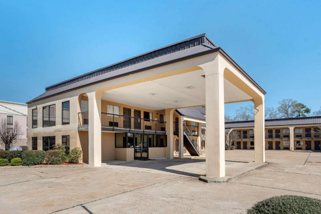 a large building with a large open garage at Econo Lodge Pearl - Jackson in Pearl