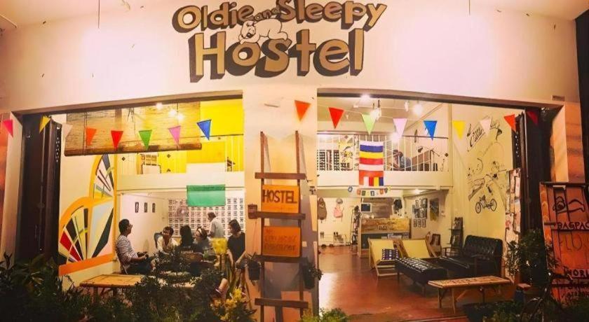 乌隆他尼Oldie and Sleepy Hostel的一间商店,里面的人坐在里面