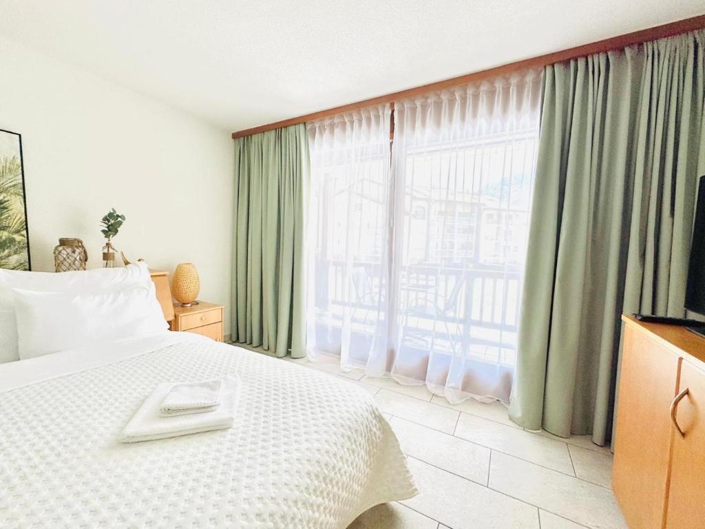 a hotel room with a bed and a large window at Studio meublé in Saillon