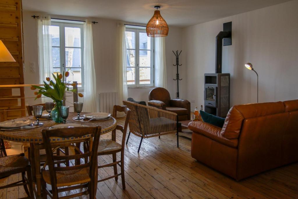 een woonkamer met een tafel en een bank bij Bel appartement centre de Cancale in Cancale