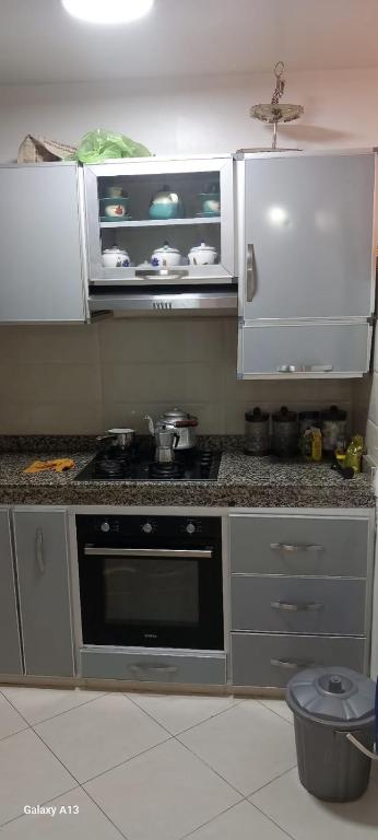 a kitchen with a stove and white cabinets at Zaafrani mohamed in El Jadida