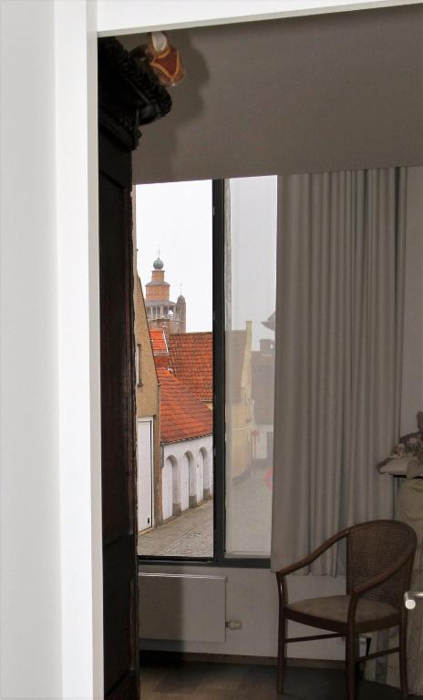 a window in a room with a chair and a building at B&B 't Walleke in Bruges