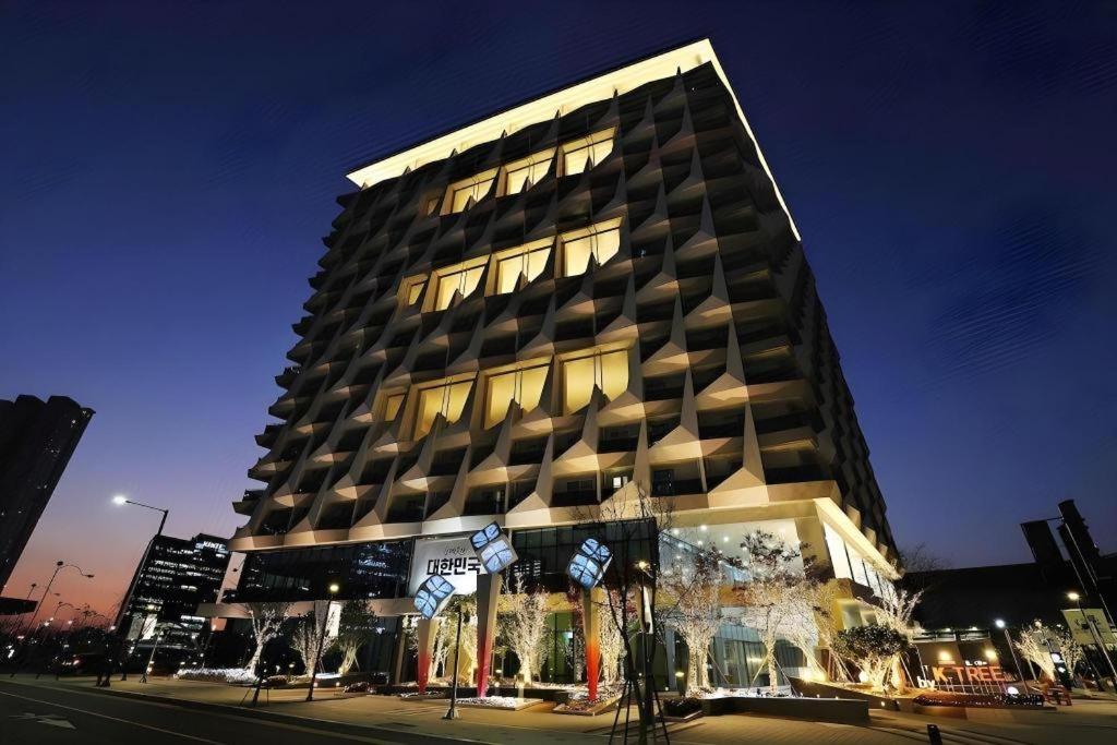 a large building with a lot of windows at night at Gloucester Hotel Kintex in Isan