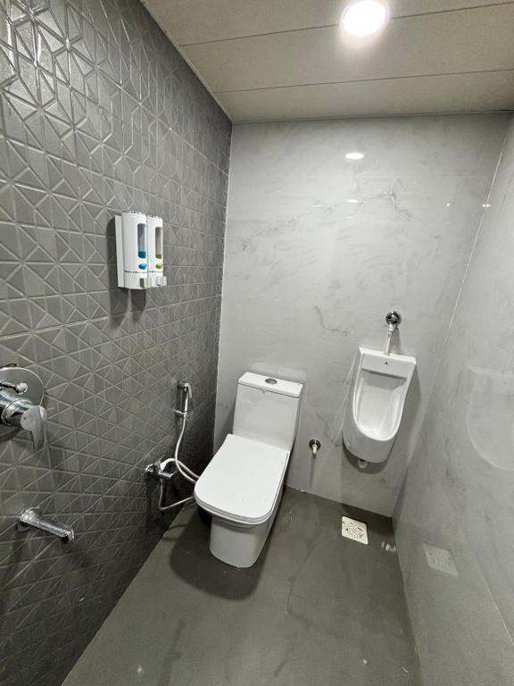 een badkamer met een toilet en een urinoir aan de muur bij The Brij Retreat , 50 mtr from Shri Krishna Janambhumi in Mathura
