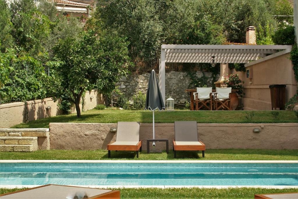 a couple of chairs sitting next to a swimming pool at Rena's House in Spílion