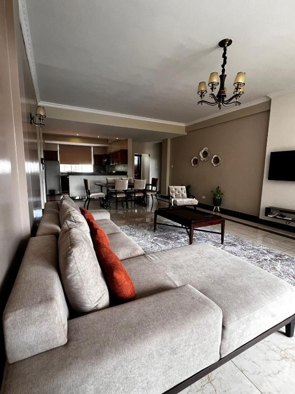 ein Wohnzimmer mit Sofa und Tisch in der Unterkunft Urban 2 Bedroom Serviced Apartment in Nakasero in Nalakonge