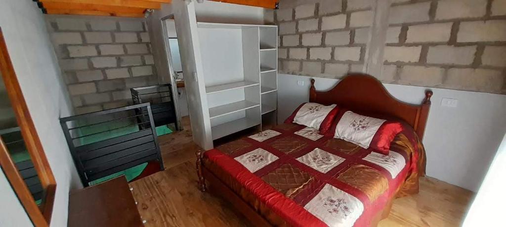 ein Schlafzimmer mit einem Bett und einer Ziegelwand in der Unterkunft Depto en playa dorada in Playa Dorada