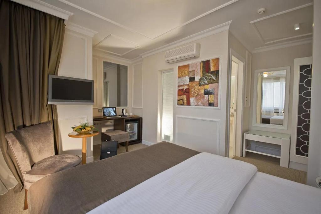 um quarto de hotel com uma cama e uma televisão em North Point Hotel em Samsun