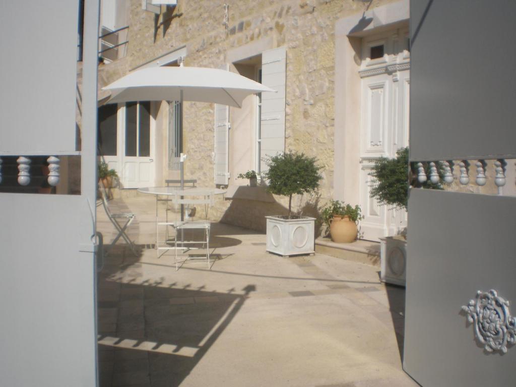 eine Terrasse mit einem Tisch und einem Sonnenschirm in der Unterkunft La Maison de Papé in Combas