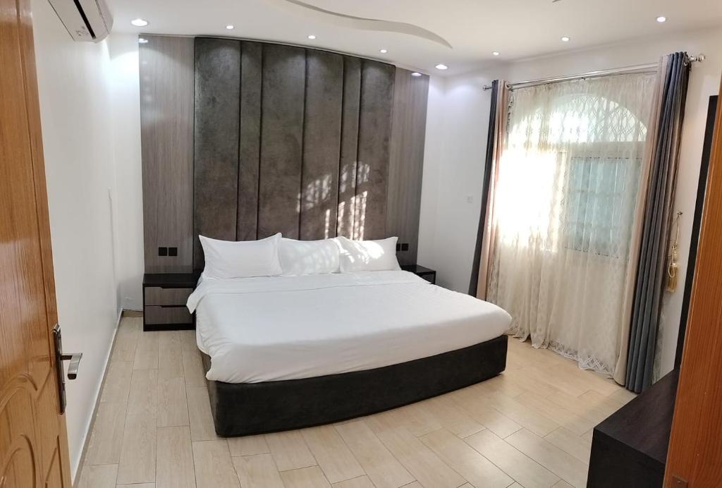 a bedroom with a large white bed with a wooden headboard at منتجع الكناري in Taif