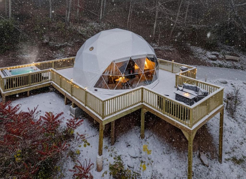 ein Kuppelhaus im Schnee auf einer Terrasse in der Unterkunft Romantic Geodesic Dome with Hot Tub, Perfect for Stargazing in Pipestem, West Virginia in Pipestem