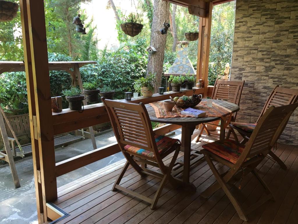 un porche con mesa de madera y sillas en Apartment Eurocoli Rezidence, en Golem