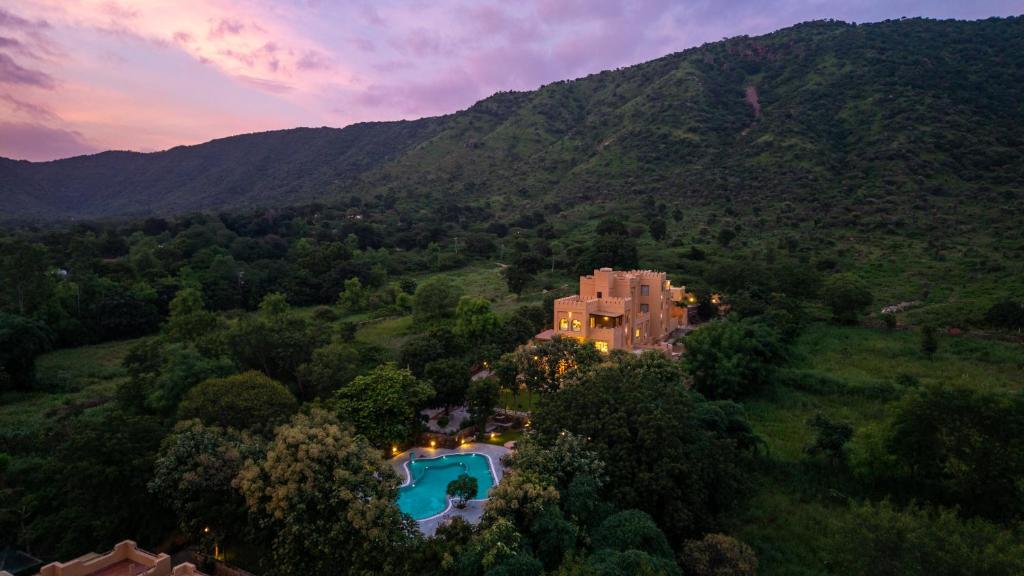 an aerial view of a house in the mountains with a swimming pool at Dev Bagh Luxurious Private Suites in Debāri