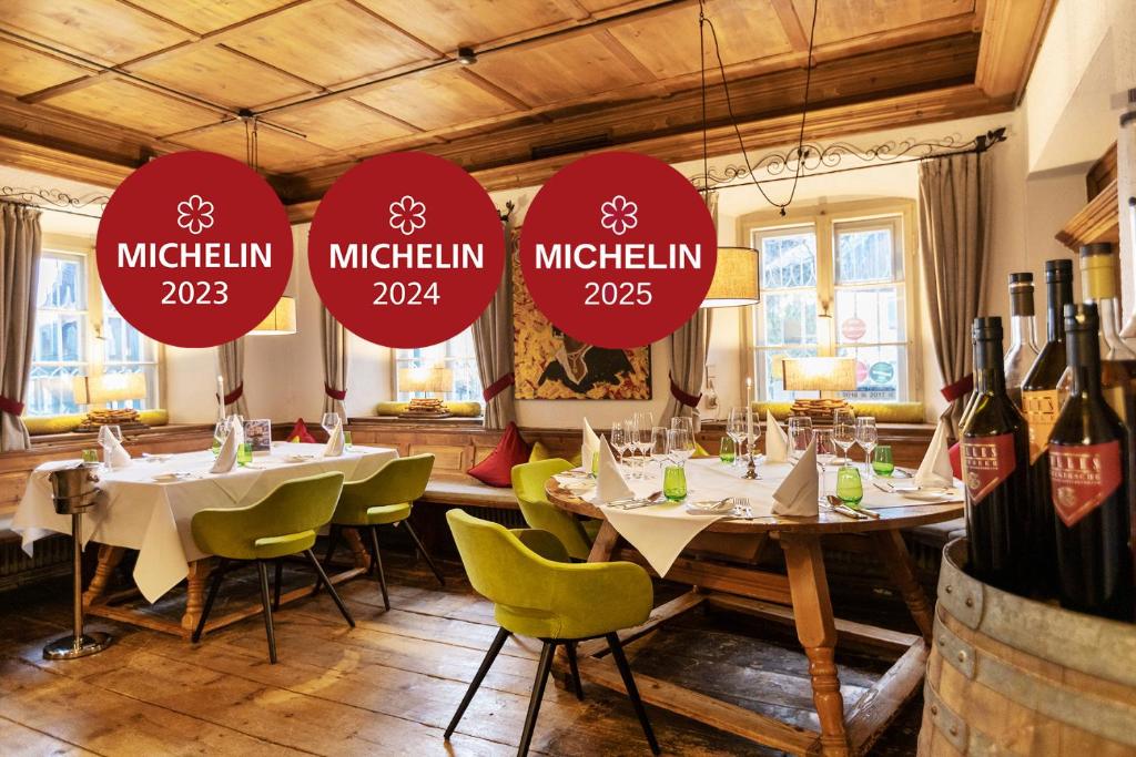 a restaurant with tables and chairs and wine bottles at Landgasthof Karner in Frasdorf