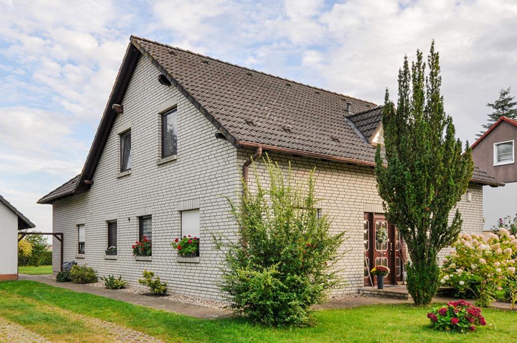 a white house with a black roof at Ferienwohnung KonradAlbrecht in Torgelow am See