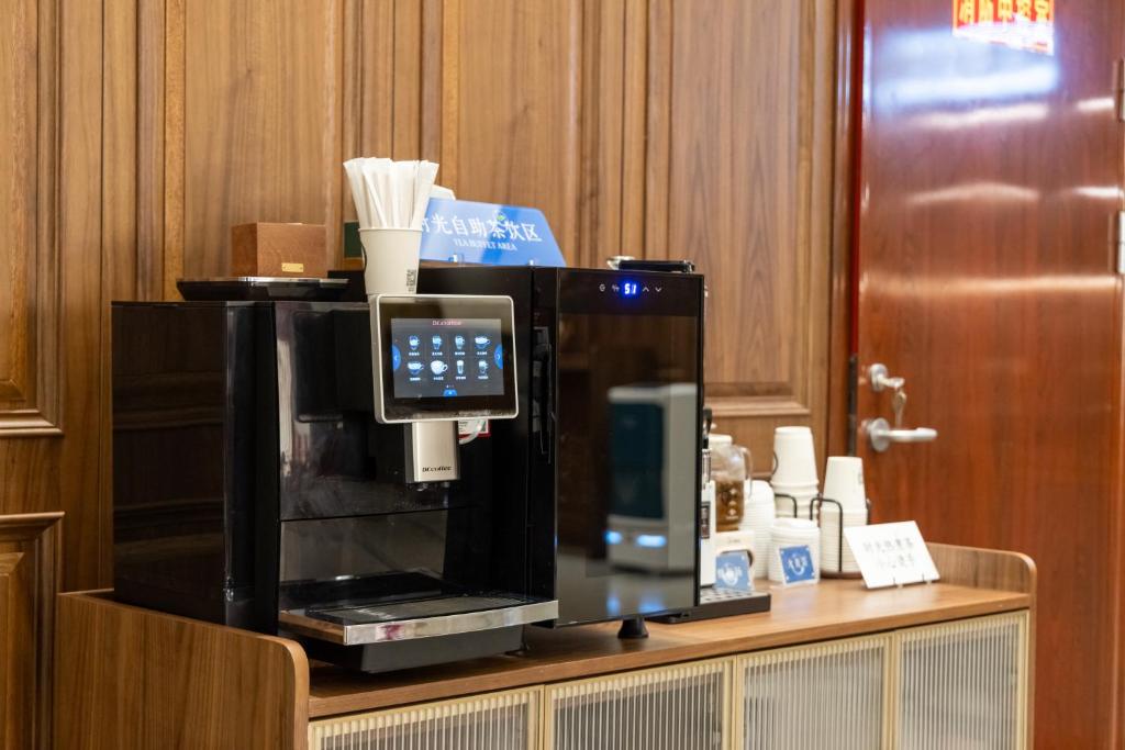 uma máquina de café numa mesa num quarto de hotel em Nostalgia S Hotel Beijing Qianmen Street & Tianqiao Performing Arts Center 时光漫步S酒店 北京前门天桥艺术中心店 Free fresh ground coffee,Free laundry service em Pequim