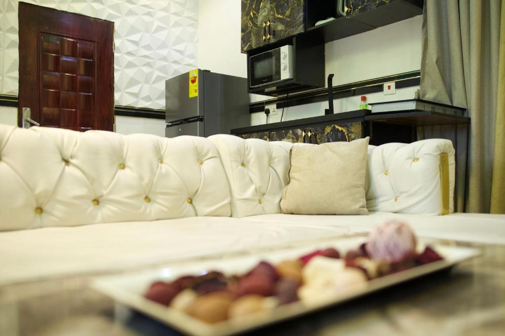 un canapé blanc avec une assiette de nourriture sur une table dans l'établissement Ft realty properties 2, à Otele