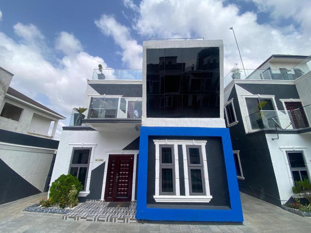 een wit en blauw huis met een rode deur bij ftrealtyproperties Tango Suites 6 in Burma Camp