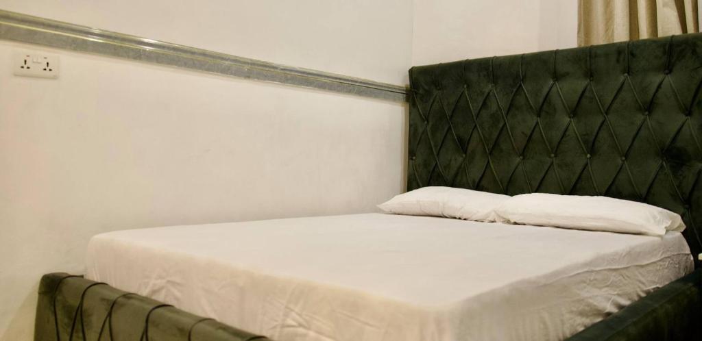 un lit avec une tête de lit noire et deux oreillers dessus dans l'établissement ftrealtyproperties Lords Hill 5, à Tokuse