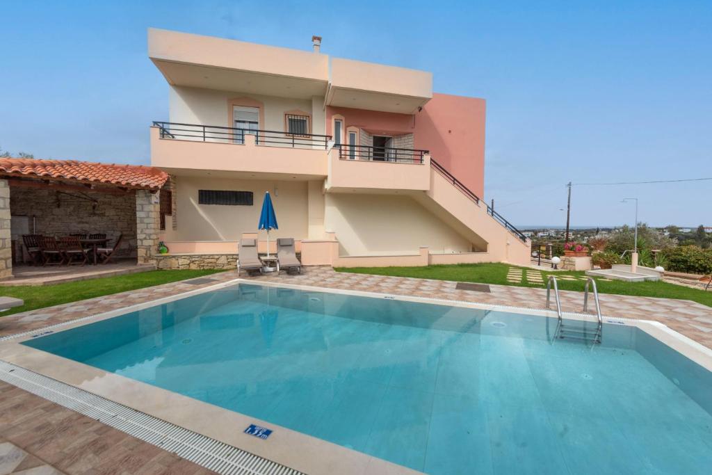 uma villa com piscina em frente a uma casa em Villa Pantelis with private pool em Agia Triada