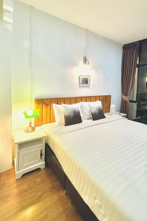 a bedroom with two beds and a lamp on a table at The Yak Cozy Chiang Mai in Chiang Mai
