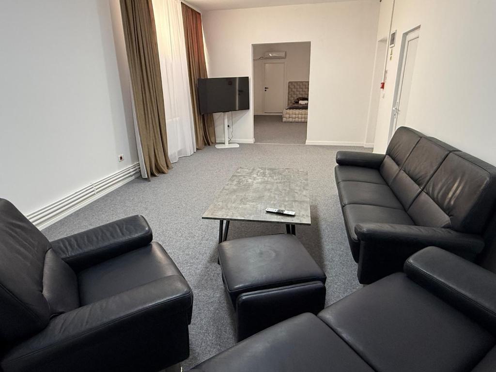 salon z czarnymi skórzanymi meblami i stołem w obiekcie Ap9 3 min from Christmas Market curte parcare w Krajowej