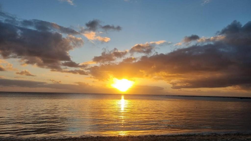 a sunset over the ocean with the sun setting at L'Escapade - Residence Harmonie in Albion